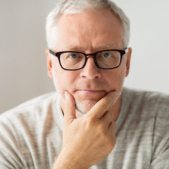 close up of senior man in glasses thinking close up of senior man in glasses thinking